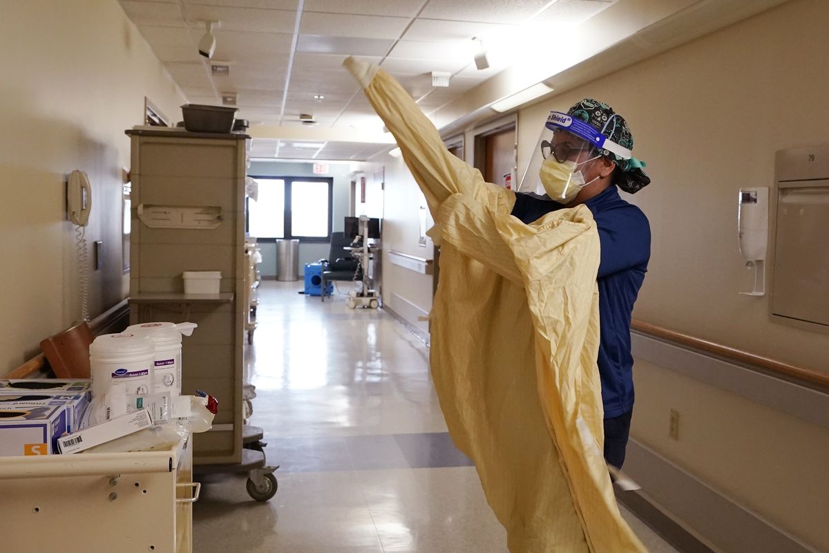 Registered Nurse Monica Quintana dons protective gear before entering a room at the William Beaumont hospital, April 21, 2021 in Royal Oak, Mich. Beaumont Health warned that its hospitals and staff had hit critical capacity levels. Michigan has become the current national hotspot for COVID-19 infections and hospitalizations at a time when more than half the U.S. adult population has been vaccinated and other states have seen the virus diminish substantially. Beaumont Health warned that its hospitals and staff had hit critical capacity levels.  (Carlos Osorio)