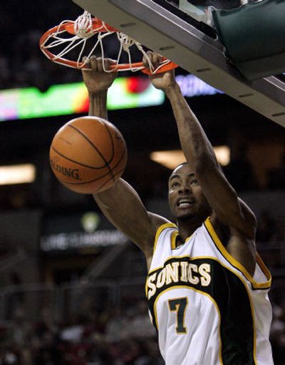 Seattle's Rashard Lewis dunks for two of his 19 points against the Timberwolves.
 (Associated Press / The Spokesman-Review)