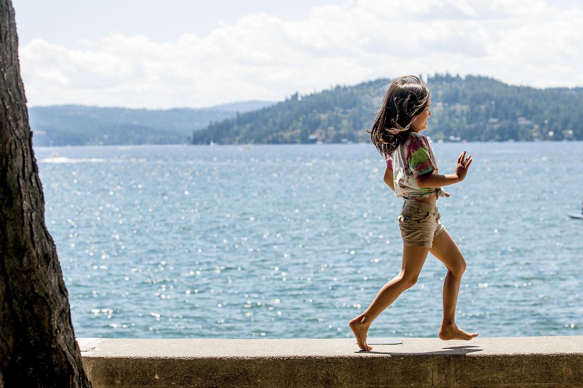 Six-year-old Yuna Kim of Vancouver, B.C., runs along the seawall at City Beach in Coeur d’Alene on Wednesday, July 20, 2016. She and her family scheduled a stop in Coeur d’Alene on their way to Yellowstone National Park. (Kathy Plonka / The Spokesman-Review)