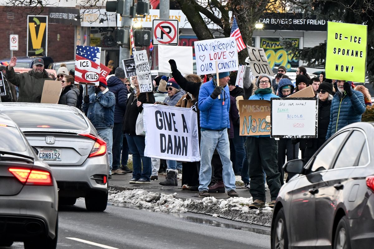 Protesters wave signs to passing motorists during an ICE Out For Good protest on Saturday in Spokane. The rally was held in solidarity with Renee Good, who was shot and killed by an ICE agent on Wednesday in Minneapolis.  (Tyler Tjomsland/The Spokesman-Review)