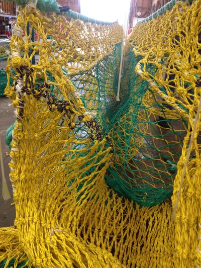 A Foulweather Trawl net hangs in Newport, Ore. These nets are a response to federal rules limiting the amount of unintended catch fishermen can haul in. (Associated Press)