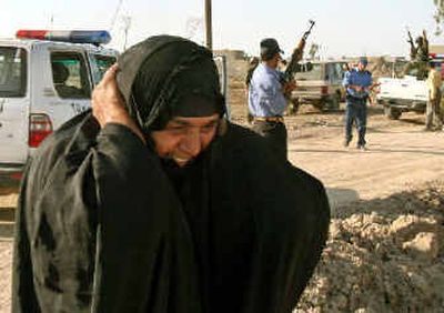 
An Iraqi woman covers her ears as gunfire breaks out in  Madain on Sunday. 
 (Associated Press / The Spokesman-Review)