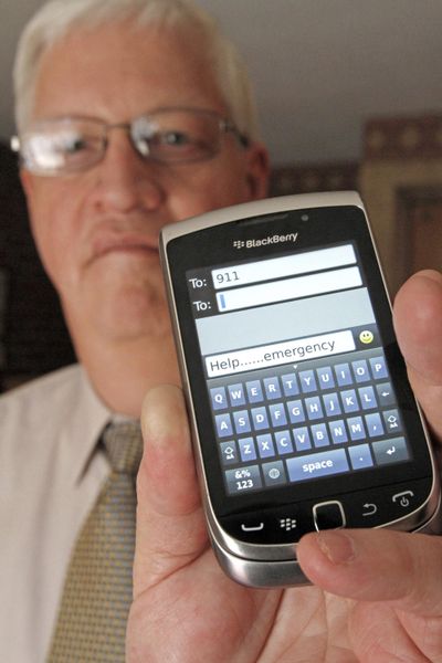 In this April 18, 2012, file photo, David Tucker, executive director of Vermont’s Enhanced 911 Board, holds a smart phone in Montpelier, Vt. Tucker  said Vermont was the first in the country where customers of the four major wireless carriers can send text messages to 911. Counties in Washington state have since expanded texting services. (Toby Talbot / Associated Press)