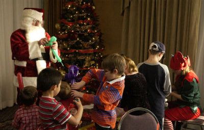 
Santa Claus, aka Michael Munter, entertains children Sunday at the H.J. Burns Company annual Christmas party at the Red Lion River Inn. Munter, who says he's a 