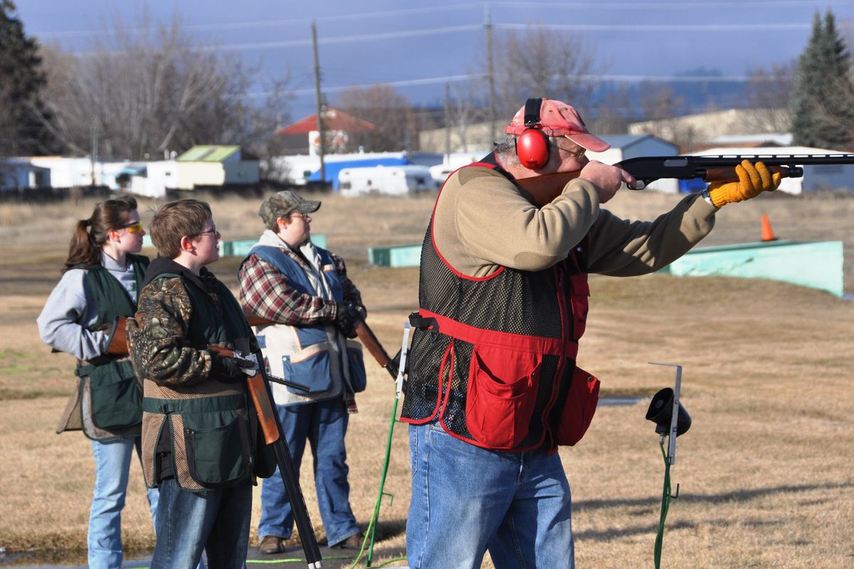 Roy Wickstrom, right, calls for a target at the Spokane Gun Club today, joined on the firing line by his family