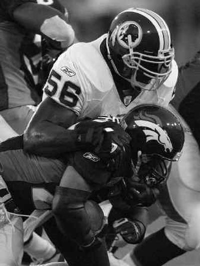 
Redskins linebacker LaVar Arrington wrestles down Broncos running back Quentin Griffin on Monday. 
 (Associated Press / The Spokesman-Review)