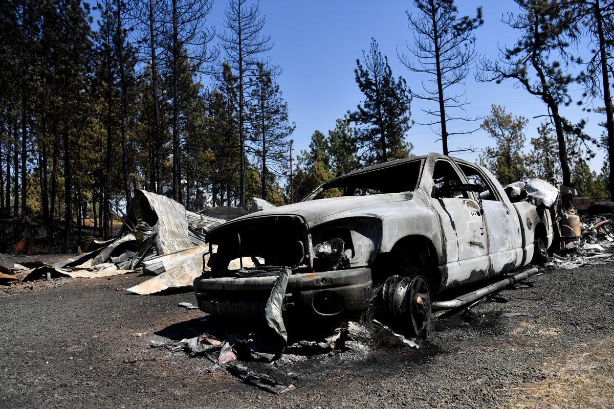 A destroyed truck and a structure are seen Wednesday at the site of the Badger Lake Fire near Cheney.  (Tyler Tjomsland/THE SPOKESMAN-REVIEW)