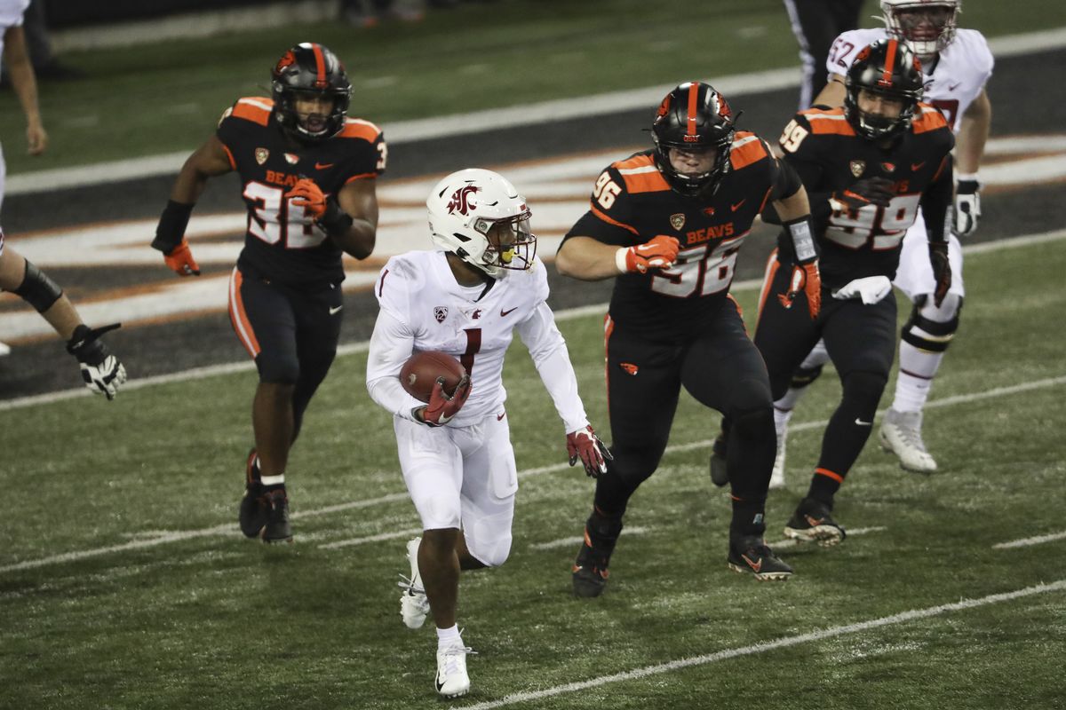 Washington State wide receiver Travell Harris (1) runs from Oregon State's Omar Speights (36), Simon Sandberg (96) and Isaac Hodgins (99) during the first half of an NCAA college football game in Corvallis, Ore., Saturday, Nov. 7, 2020.  (Associated Press)