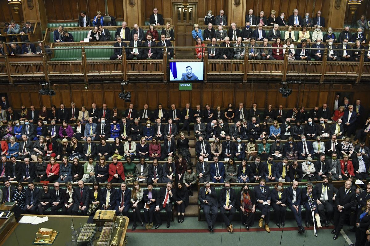 In this photo provided by UK Parliament, Ukrainian President Volodymyr Zelenskyy is displayed on the screen as he addresses British lawmakers in the House of Commons in London, Thursday March 8, 2022. Speaking by video link, the Ukrainian leader urged the U.K. to increase sanctions on Russia, to recognize Russia as “a terrorist country” and to keep Ukraine’s skies safe. He was given a standing ovation by members from all parties in the House of Commons.  (Jessica Taylor)