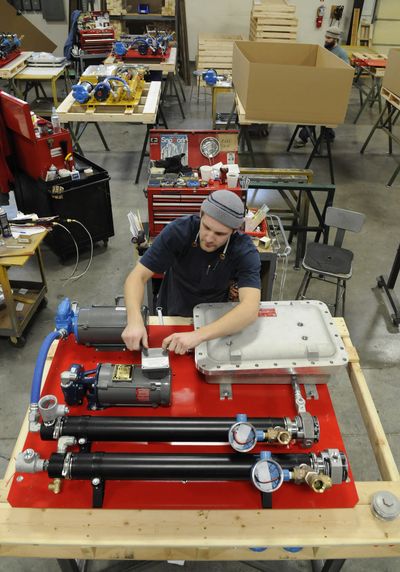 Jason Cook helps assemble a dual circulating coolant system at Kim Hotstart, a privately held company that makes heating and pre-fuel diesel engine warmers.  (Colin Mulvany / The Spokesman-Review)