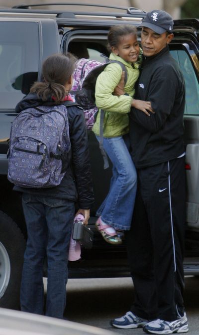 President-elect Barack Obama lifts his daughter Sasha out of his vehicle as daughter Malia looks on as he drops them off at school in Chicago earlier this month.  (File Associated Press / The Spokesman-Review)