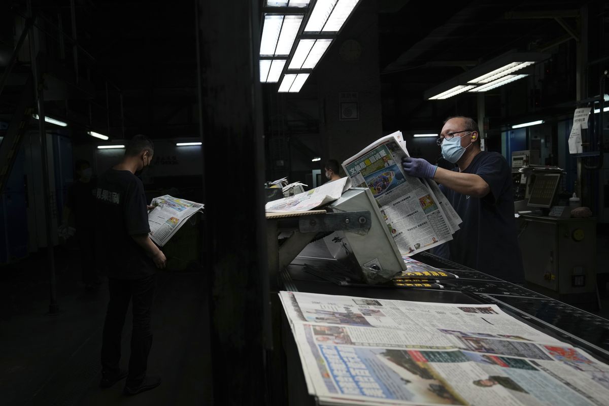 Workers check the copies of Apple Daily newspaper at the printing house in Hong Kong, early Friday, June 18, 2021. Five editors and executives at pro-democracy Apple Daily newspaper were arrested Thursday under Hong Kong