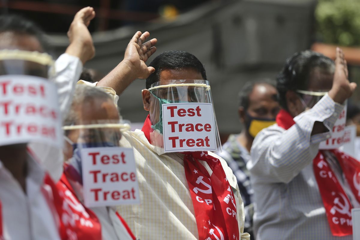 Activists of Communist Party of India Marxist display placards on face shields and shout slogans during a protest asking the state government to increase testing and free treatment for all COVID-19 patients in Hyderabad, India, Monday, June 29, 2020. Governments are stepping up testing and warily considering their next moves as the number of newly confirmed coronavirus cases surges in many countries. India reported more than 20,000 new infections on Monday.  (Mahesh Kumar A)