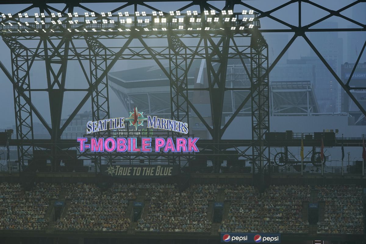 Smoke from wildfires fills the air at T-Mobile Park as photos of fans are displayed in the left field bleachers and CenturyLink Field is visible behind the ballpark sign during the second baseball game of a doubleheader between the Seattle Mariners and the Oakland Athletics, Monday, Sept. 14, 2020, in Seattle.  (Associated Press)