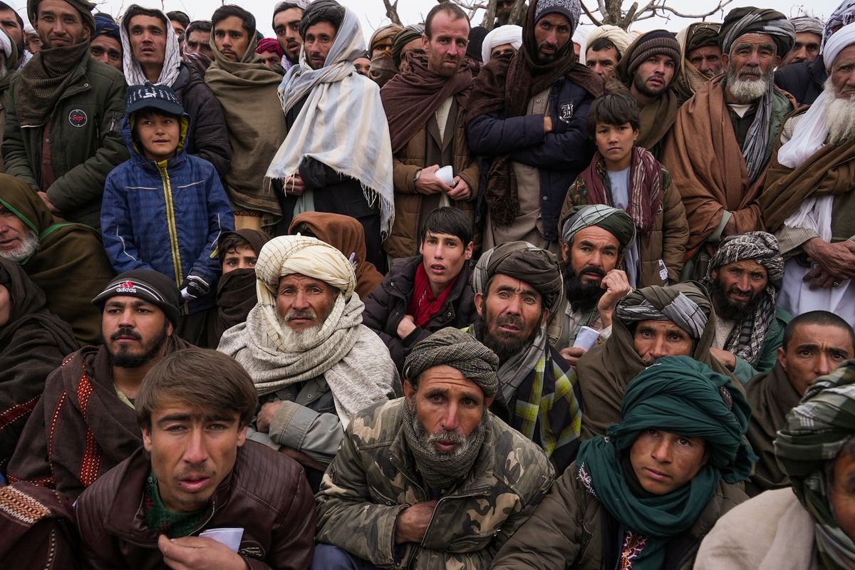 FILE - Hundreds of Afghan men gather to apply for the humanitarian aid in Qala-e-Naw, Afghanistan, Tuesday, Dec. 14, 2021. In a statement Tuesday, Jan. 11, 2022, the White House announced $308 million in additional humanitarian assistance for Afghanistan, offering new aid to the country as it edges toward a humanitarian crisis since the Taliban takeover nearly five months earlier.  (Mstyslav Chernov)