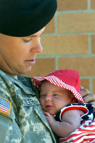 
Specialist Jon Mittler of Spokane holds his 22-day-old daughter, Kaida, on Saturday after the ceremony to send Mittler's unit to Iraq. 
 (Jesse Tinsley / The Spokesman-Review)
