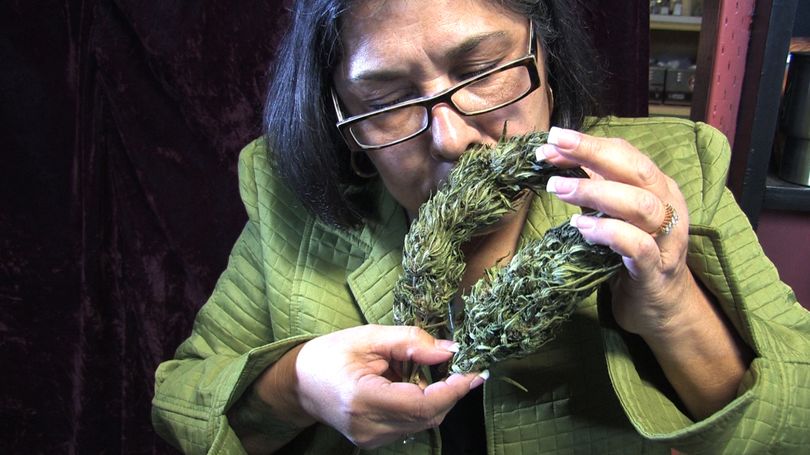 Madeline Martinez, executive director of the Oregon chapter of the National Organization for the Reform of Marijuana Laws, smells marijuana buds at the Cannabis Café on Nov. 17.   (Associated Press)