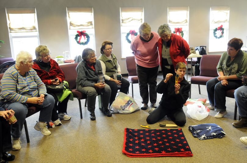 Erin Haugh shows a group of the Valley Assembly Quilters a tool that she uses to punch holes on the edge of a quilt in preparation for lacing or crocheting. The group meets in a donated room at the Valley Assembly of God, shares a common interest in quilting and provides quilts to Providence Sacred Heart Medical Center’s cancer unit. (J. Bart Rayniak)