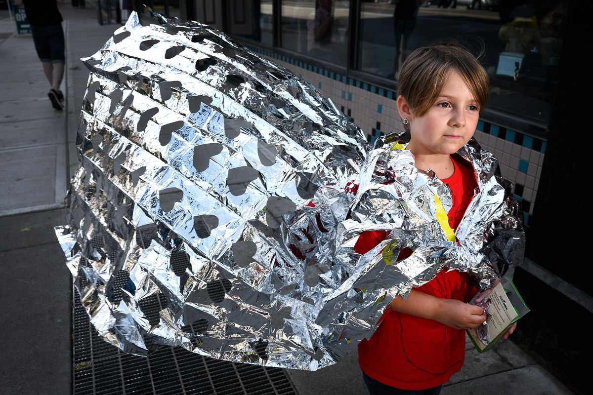 At the Close the Camps rally in downtown Spokane on Tuesday, Josephine Lazcano, 6, wears a cape made out of a Mylar blanket, the same type that children in immigrant detention camps are sleeping in. (Colin Mulvany / The Spokesman-Review)