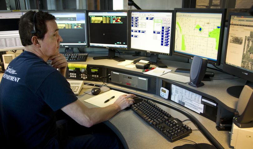 At the Spokane County regional fire dispatch center, dispatcher Mike Cappellano monitors a call of a tree that fell onto a house Wednesday. (Colin Mulvany)