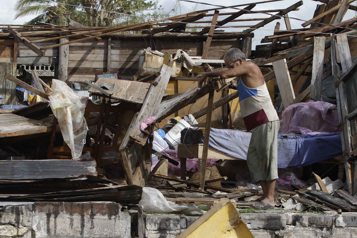 Resident Antonio Garces tries to recover his belongings from his house destroyed by Hurricane Sandy in Aguacate, Cuba, Thursday Oct. 25, 2012. Hurricane Sandy blasted across eastern Cuba on Thursday as a potent Category 2 storm and headed for the Bahamas after causing at least two deaths in the Caribbean. (Franklin Reyes / Associated Press)