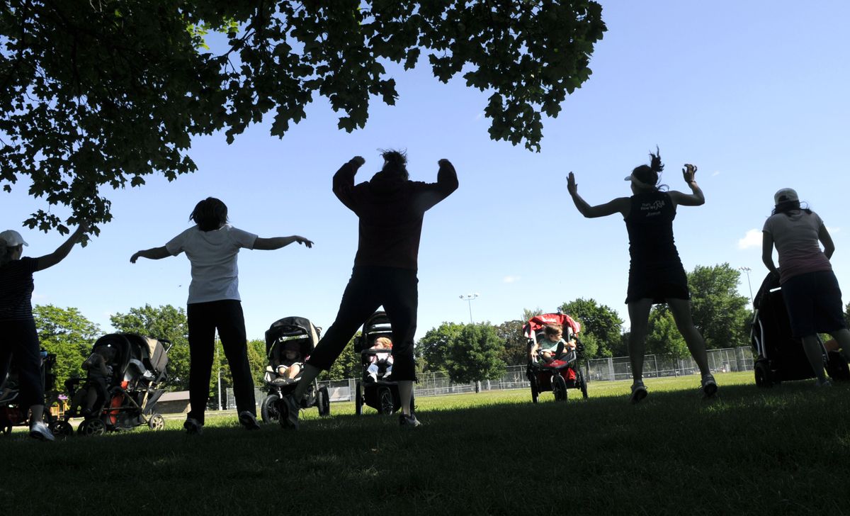 Colleen Connell leads a group of women through an exercise routine under a shade tree at Mission Park. (Dan Pelle / The Spokesman-Review)