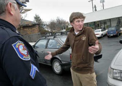 
Miles Rasley, 17, explains to Spokane Police Cpl. Jon Strickland what happened to his Honda Wednesday in a hit-and-run accident at the corner of Indiana and Washington. 
 (Dan Pelle / The Spokesman-Review)