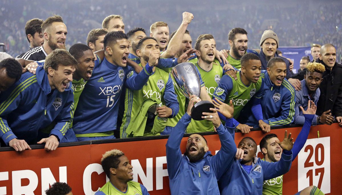 Seattle Sounders’ Clint Dempsey holds the championship trophy up as teammates cheer around him after the Sounders defeated the Houston Dynamo 3-0 in the second leg of the MLS soccer Western Conference final, Thursday, Nov. 30, 2017, in Seattle. The Sounders advanced to the MLS Cup. (Elaine Thompson / Associated Press)