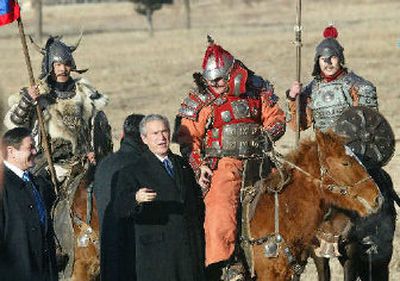 
President George W. Bush stops to greet Mongolians in traditional costumes. He visited the Ikh Tenger with Mongolia's President Nambaryn Enkhbayar, left, on Monday. 
 (Associated Press / The Spokesman-Review)