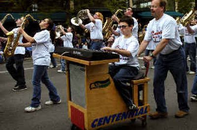 
Centennial Middle School seventh-grader Cody Lorenz plays a keyboard on a cart pushed by parent volunteer Kurt Alsperger during the 54th annual Junior Lilac Parade on Saturday morning. The Centennial band won second place in the Band – Division 2 category.
 (Holly Pickett photos/ / The Spokesman-Review)