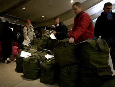 
From left, Airman Ross Anderson, Staff Sgt. Robert Owens and Airman Keith DeJongh line up their bags before checking in Saturday at the Spokane  airport. 
 (Liz Kishimoto / The Spokesman-Review)