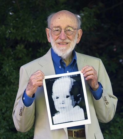 FILE - In this 2007 file photo ,Russell Kirsch holds the image of his son, Walden, that was scanned into the world's first digital scanner in 1957. Russell Kirsch, a computer scientist credited with inventing the pixel and scanning the world’s first digital photograph, died Aug. 11, 2020 at his home in Portland, Oregon, The Oregonian reported. He was 91.  (Jamie Francis)