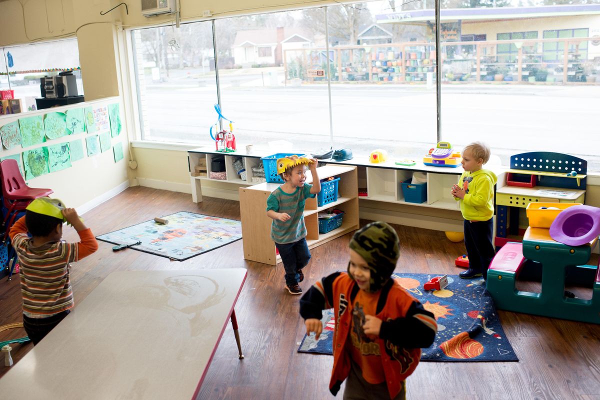 Leium Vann, center blue, chases classmates while wearing a dinosaur mask during a preschool class on March 15, 2017, at Little Rascals Children’s Center in Spokane. (Tyler Tjomsland / The Spokesman-Review)
