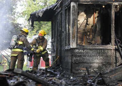 Firefighters sift through debris after the Denennys' fire on South Virginia in Spokane Valley. The homeowners were out of town during the blaze.
 (no photographer / The Spokesman-Review)