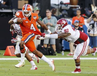 Clemson quarterback Deshaun Watson runs with the ball as Oklahoma defensive tackle Matthew Romar attempts to stop him in last year’s college football semifinals. Future semifinals may not be played on New Year’s Eve. (Joe Skipper / Associated Press)