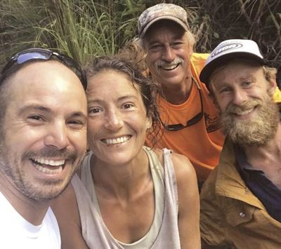 In this Friday, May 24, 2019, photo provided by Troy Jeffrey Helmer, resident Amanda Eller, second from left, poses for a photo after being found by searchers, Javier Cantellops, far left, Helmer and Chris Berquist above the Kailua reservoir in East Maui, Hawaii, on Friday afternoon. (Troy Helmer / Associated Press)