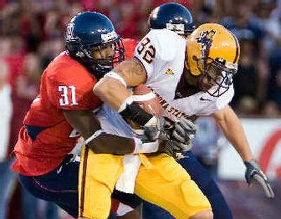 
Arizona's Michael Klyce (31) wraps up ASU's Jamaal Lewis.
 (Associated Press / The Spokesman-Review)