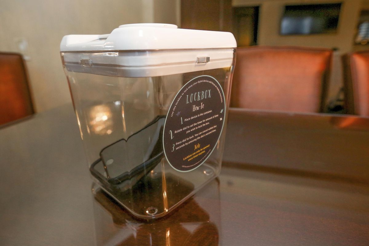 This Dec. 1, 2018 photo shows a locked box holding cellphones during a digital detox visit to the Wyndham Grand Hotel in Chicago. A growing number of hotels are helping guests take a vacation from their vacation by offering incentives to guests willing to lock up their cell phones. (Teresa Crawford / AP)