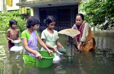 
Residents collect water from a submerged hand pump in Dhaka, Bangladesh, on Sunday. Bangladesh's death toll from this year's monsoon rains has reached 227, and the situation is likely to worsen, officials say.
 (Associated Press / The Spokesman-Review)