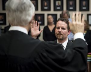 Superior Court Judge Michael Price (back to camera) swears in new Spokane County Superior Court Judge Tony Hazel during an investiture held Friday, May 5, 2017, at the Gonzaga University Law School. (Colin Mulvany / The Spokesman-Review)