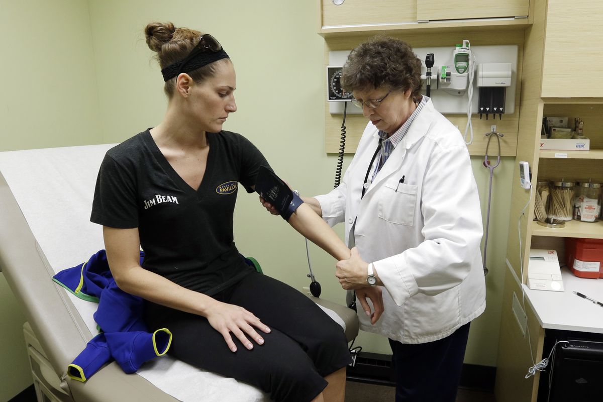 Family nurse practitioner Ruth Wiley examines Elizabeth Knowles at a Walgreens Take Care Clinic in Indianapolis. (Associated Press)