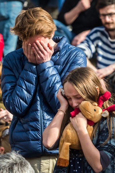 A young man and a girl react as they stand Saturday at a memorial site at the Place de la Bourse in Brussels. (Geert Vanden Wijngaert / Associated Press)