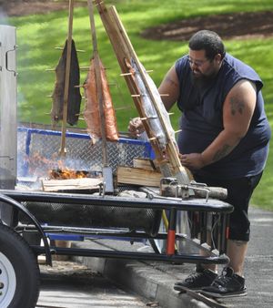 OLYMPIA -- A member of the Chehalis Tribe cooks king salmon over an open flame in preparation for a ceremony marking the 50th anniversary of the sister state relationship between Washington and Hyogo prefecture, Japan. (Jim Camden)