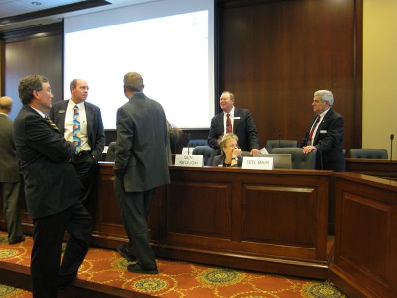 Members of the Joint Economic Outlook & Revenue Assessment Committee mix and discuss during a 10-minute break before a key vote Wednesday. (Betsy Russell)