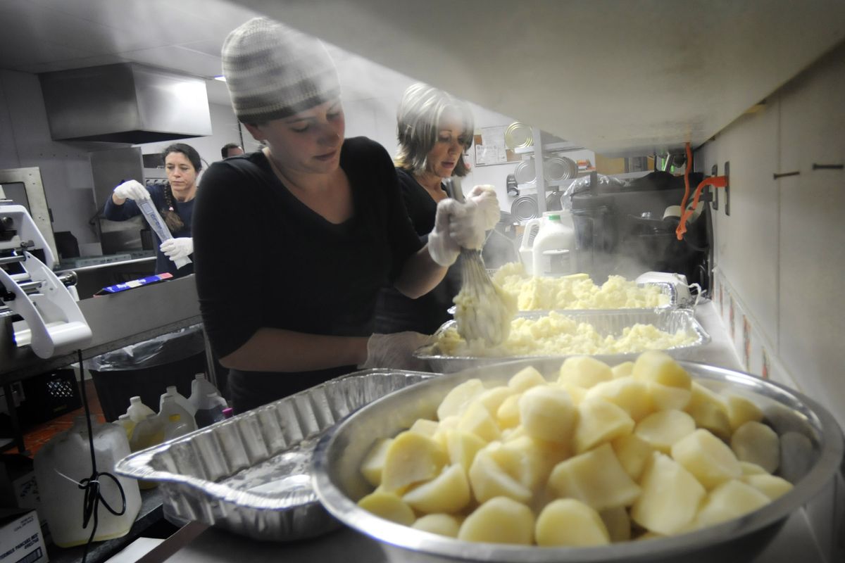 Sandy Kay, rear left, Laura Herbig, center, and Laura Walker help prepare Thanksgiving dinner at Mid-City Concerns on Thursday.  (Christopher Anderson)