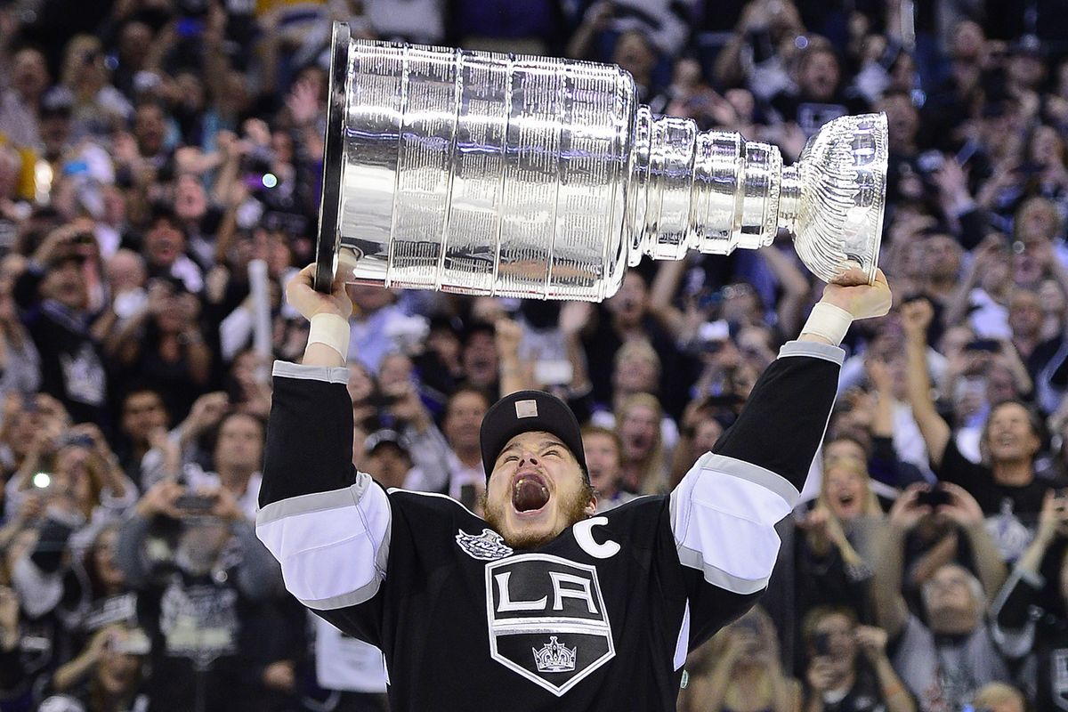 Kings right winger Dustin Brown holds up the Stanley Cup after helping Los Angeles win the first championship in the franchise’s 45-year history. (Associated Press)