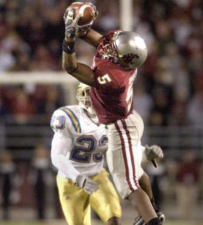 
Michael Bumpus leaps to catch an Alex Brink pass over the defense of UCLA's Justin Fareed. The Spokesman Review
 (CHRISTOPHER ANDERSON The Spokesman Review / The Spokesman-Review)