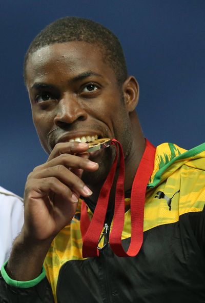 Andrew Riley of Jamaica likes the taste of his gold medal after winning the 110 meter hurdles in the Commonwealth Games. (Associated Press)