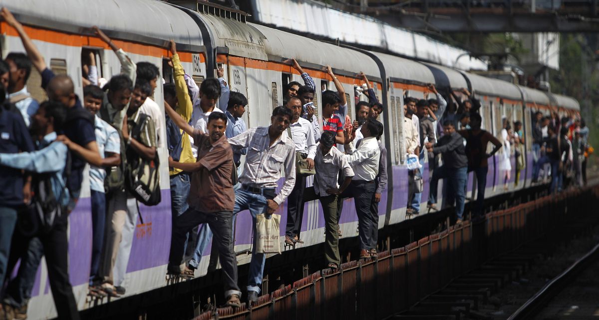Commuters hang on to a local train in Mumbai, India. India is the second-most populous country in the world, with 1.2 billion people. (Associated Press)