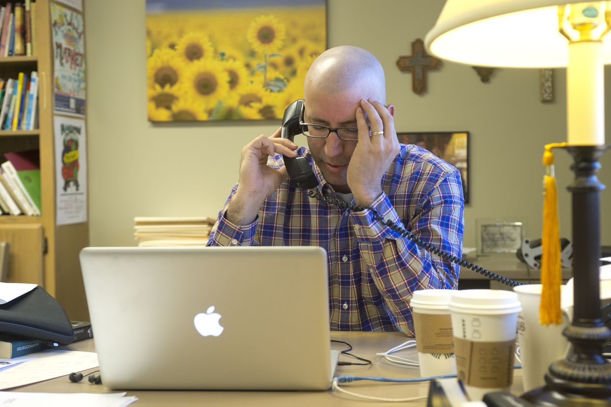 At Millwood Presbyterian Church, the Rev. Craig Goodwin forgets his diagnosis of lymphoma for a moment and prays over the phone with a parishioner experiencing a family crisis on Oct. 22. (Jesse Tinsley)